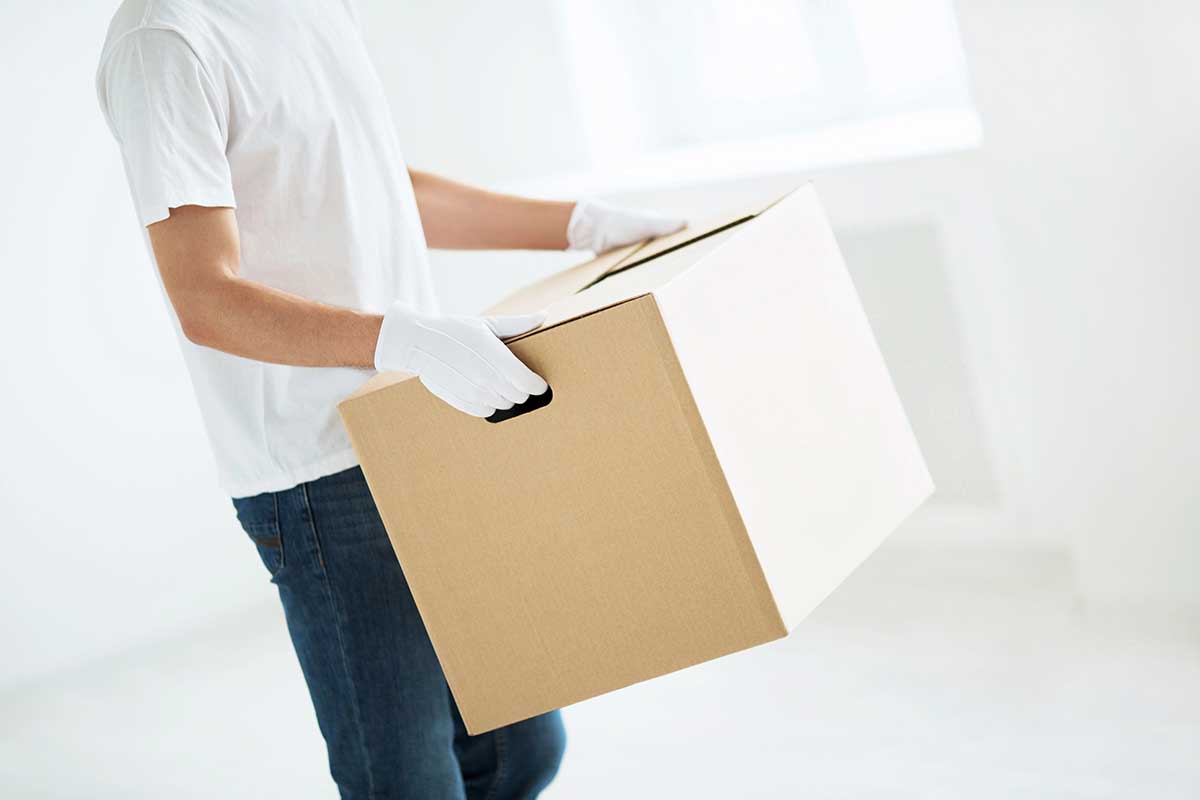 A mover wearing white gloves handling premium furniture